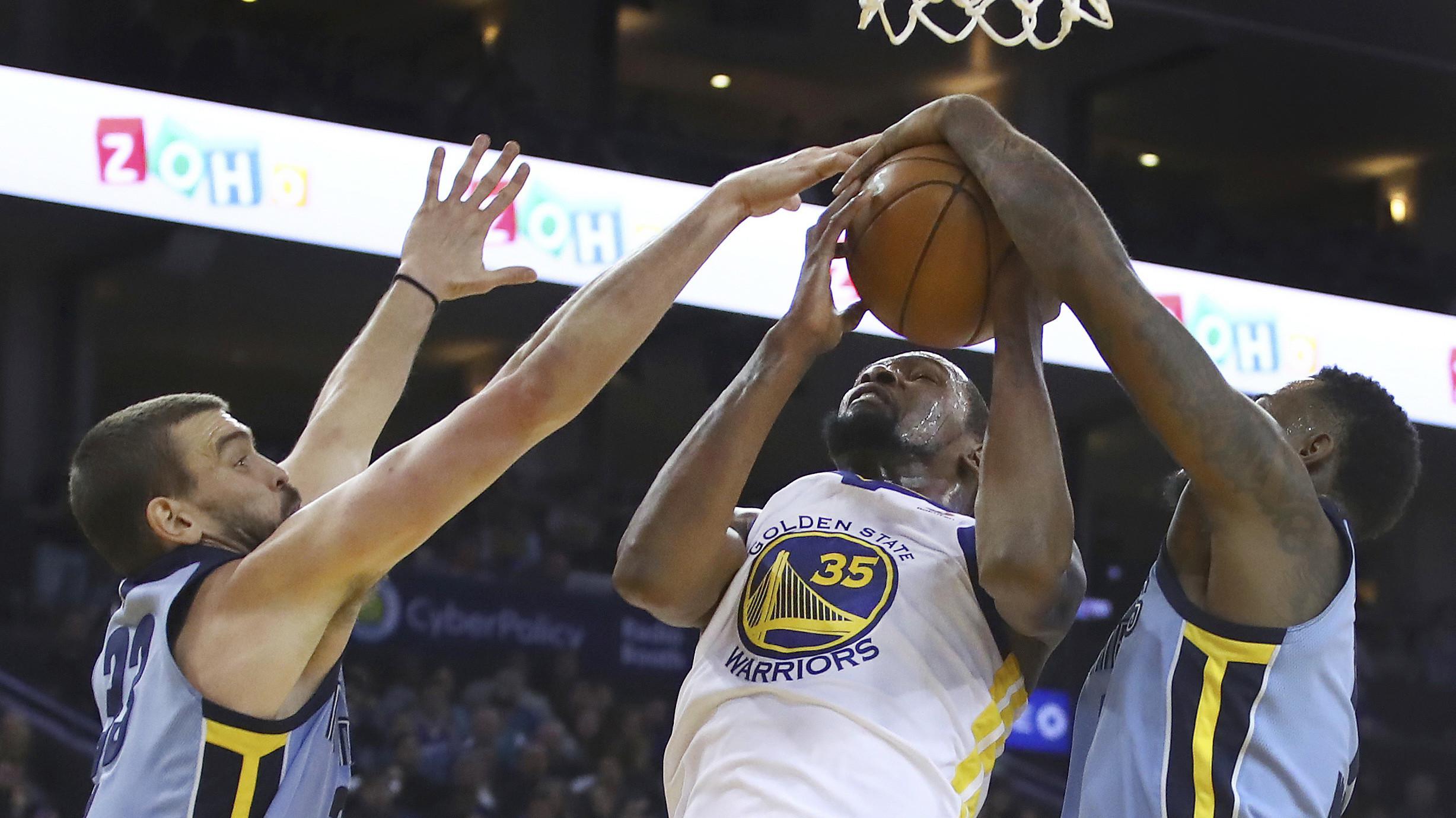 Pemain Golden State Warriors, Kevin Durant (tengah) berebut bola dengan para pemain Memphis Grizzlies pada laga NBA basketball games di ORACLE Arena, Oakland (20/12/2017). Warriors menang 97-84. (AP/Ben Margot)