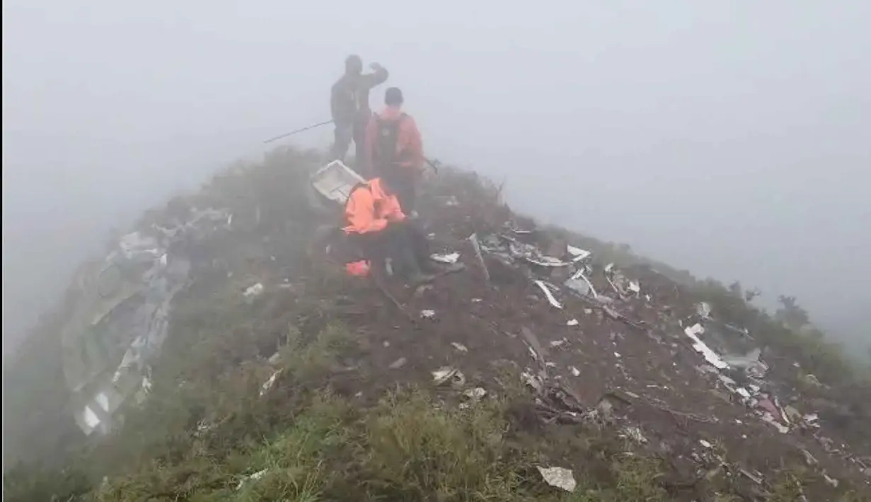 Dalam foto yang disediakan oleh Badan Nasional Pencarian dan Penyelamatan Indonesia (BASARNAS), anggota tim penyelamatnya melakukan operasi pencarian di tengah puing-puing pesawat di sekitar Gunung Bulusaraung, Provinsi Sulawesi Selatan, Minggu 18 Januari 2026, setelah pesawat turboprop ATR 42-500 kehilangan kontak pada hari Sabtu (17/1/2026). (BASARNAS via AP)