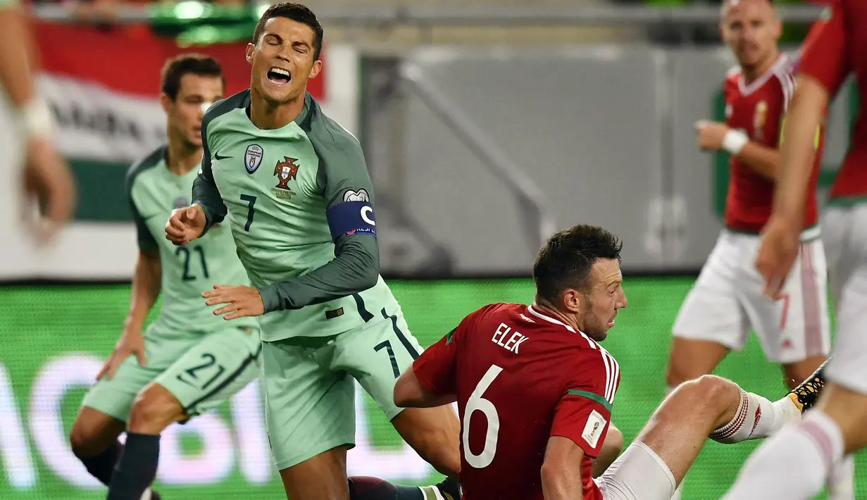 Striker Portugal, Cristiano Ronaldo, terjatuh saat dilanggar pemain Hongaria, Akos Elek, pada laga Kualifikasi Piala Dunia 2018 di Stadion Groupama, Minggu (3/9/2017). Portugal menang 1-0 atas Hongaria. (AP/Tibor Illyes)