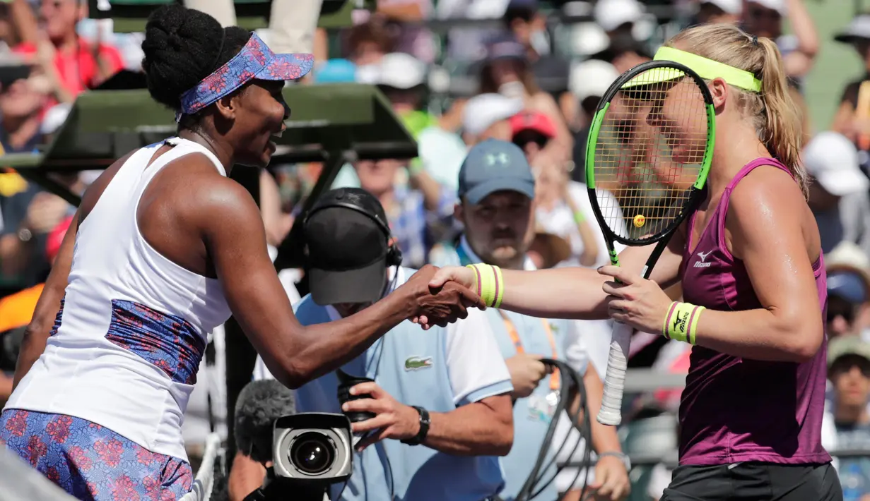 Unggulan delapan Venus Williams dan petenis Belanda, Kiki Bertens berjabat tangan seusai pertandingan hari ketujuh Miami Terbuka di Crandon Park, Minggu (25/3).  Venus susah payah lolos ke babak 16 besar dengan skor 5-7, 6-3, 7-5. (AP/Lynne Sladky)