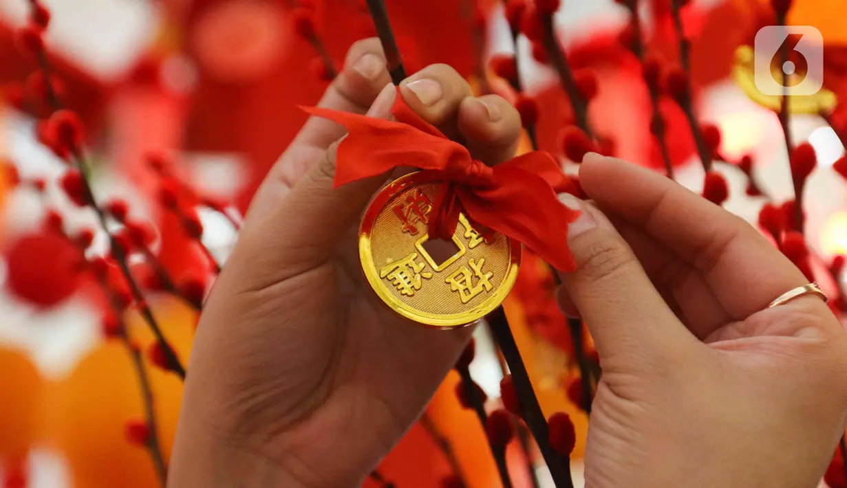 Koin diletakan di Instalasi Red Lunar di Mal Senayan City, Jakarta, Kamis (19/1/2023). Pengunjung bisa menikmati Instalasi yang indah ini mulai dari 14 Januari – 5 Februari 2023. (Liputan6.com/Herman Zakharia)