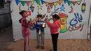 Beberapa anak tampak antusias menggantung hiasan sederhana di antara tali-tali penyangga tenda. Tampak dalam foto, para pengungsi muda Palestina bermain dengan lampion Ramadan saat dekorasi dipasang di samping tenda mereka di kamp pengungsi Bureij di Jalur Gaza tengah pada 15 Februari 2026. (Eyad Baba/AFP)
