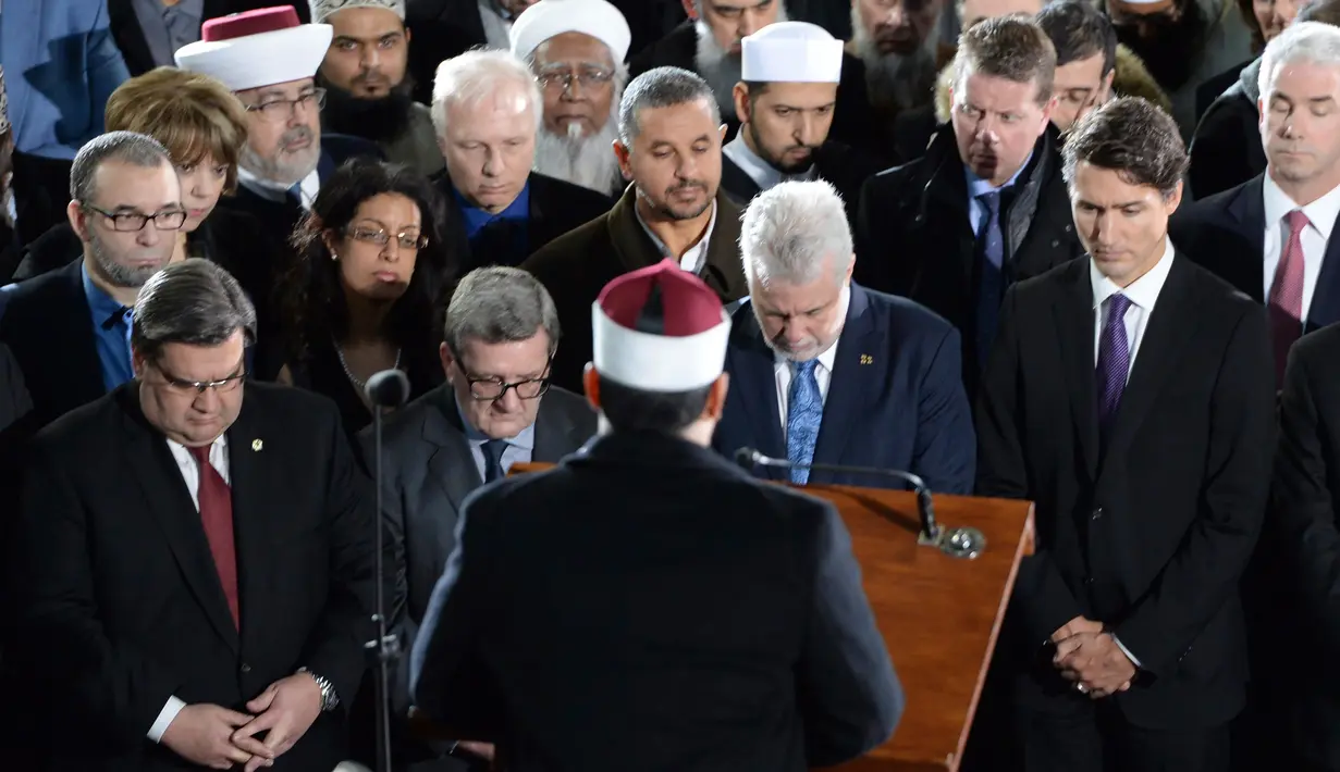 Perdana Menteri (PM) Kanada, Justin Trudeau (kanan) bersama Wali Kota Quebec, Philippe Couillard menghadiri upacara pemakaman tiga dari enam korban penembakan di Masjid Quebec, di Montreal Olympic, Kamis (2/2). (Paul Chiasson/The Canadian Press via AP)