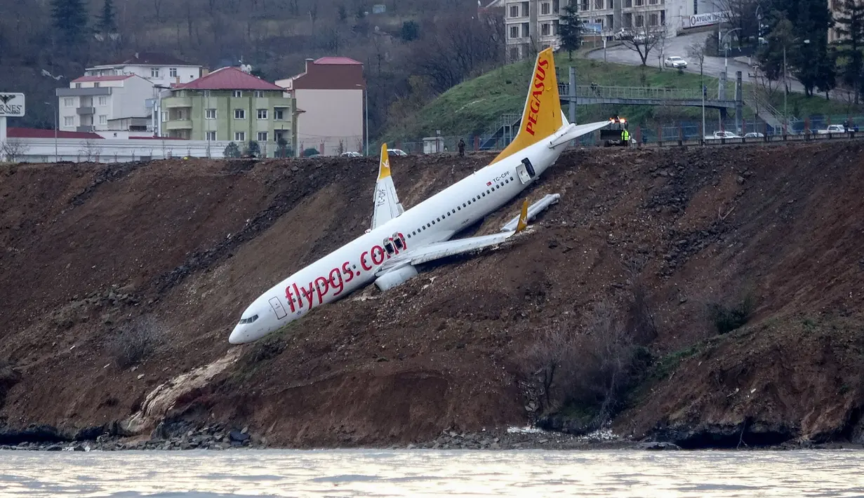 Pesawat maskapai Pegasus Airlines yang nyaris terperosok ke dalam laut saat mendarat di bandara Trabzon, Turki, Minggu (14/1). Beruntung, seluruh penumpang maupun awak pesawat tidak terluka dan dapat  segera dievakuasi. (DOGAN NEWS AGENCY/AFP)