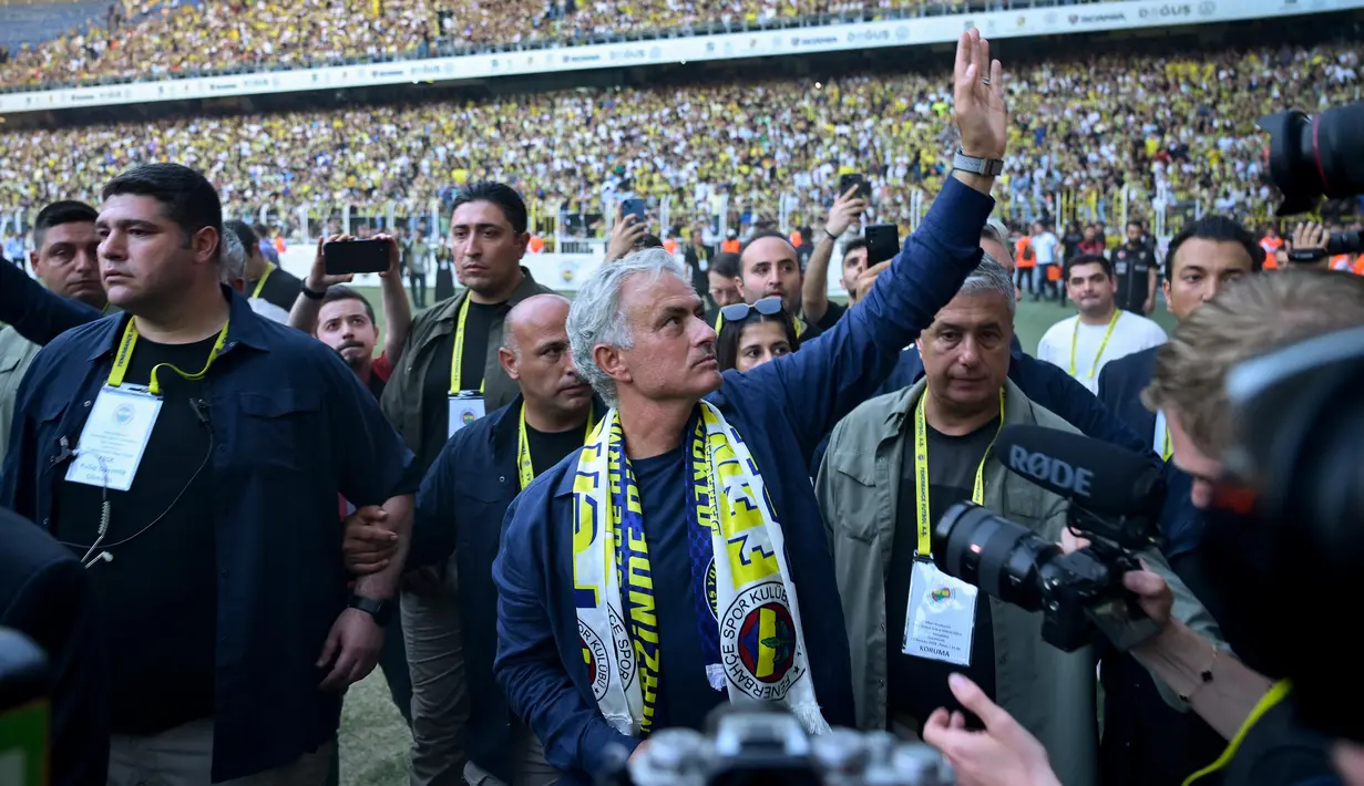 Pelatih baru klub Turki Fenerbahce, Jose Mourinho (tengah) melambaikan tangan saat memberikan sambutan kepada para suporter di Stadion Sukru Saracoglu, Istanbul, 2 Juni 2024. (Yasin AKGUL/AFP)