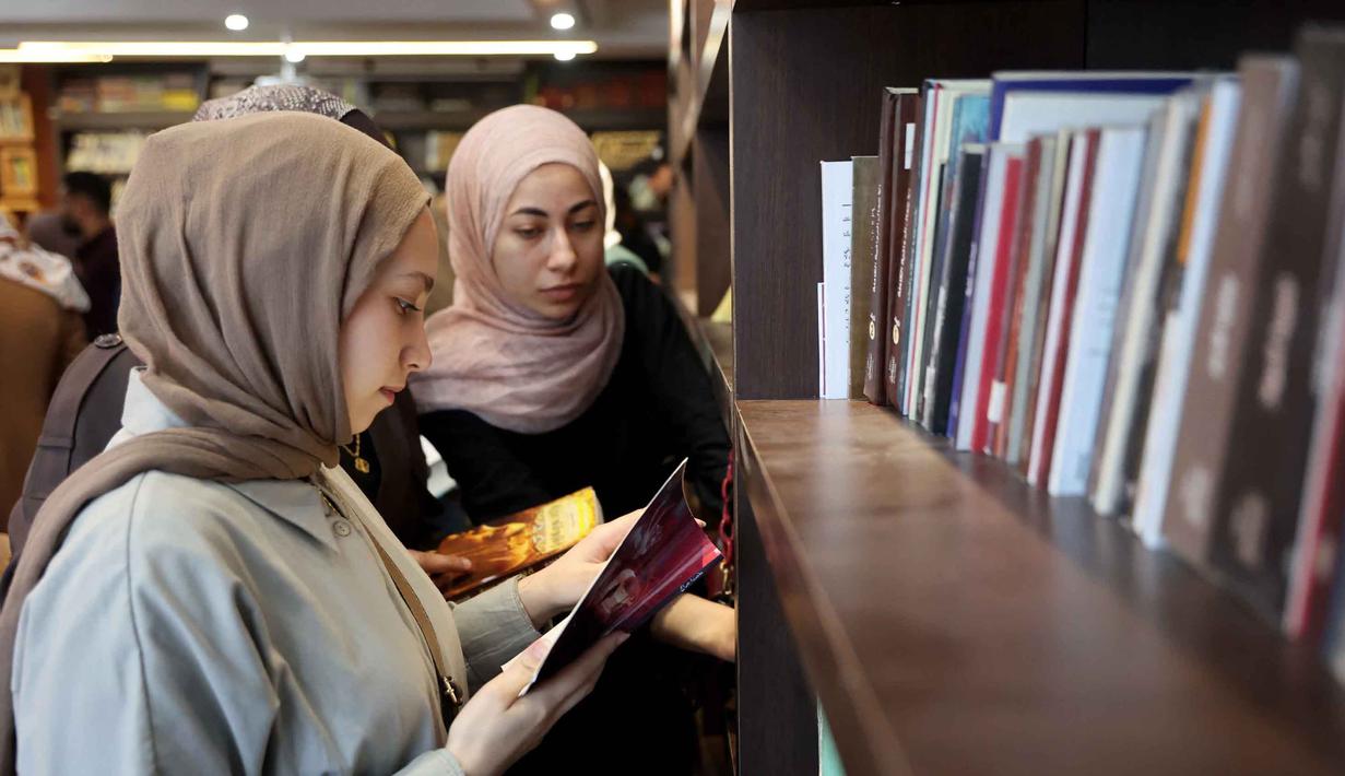 Melalui perpustakaan ini, Omar Hamad, menyelamatkan buku-buku yang tersisa, menjaga ingatan dan budaya Palestina, serta memberi ruang bagi anak-anak untuk terus belajar dan bermimpi. Tampak dalam foto, para pengungsi Palestina membaca buku di perpustakaan Al-Ankaa (Phoenix), perpustakaan pertama yang dibuka sejak gencatan senjata di Jalur Gaza yang berisi buku-buku yang diselamatkan dari perpustakaan yang hancur selama perang Israel-Hamas, di lingkungan Rimal, Kota Gaza pada Selasa 21 April 2026. (Omar AL-QATTAA/AFP)
