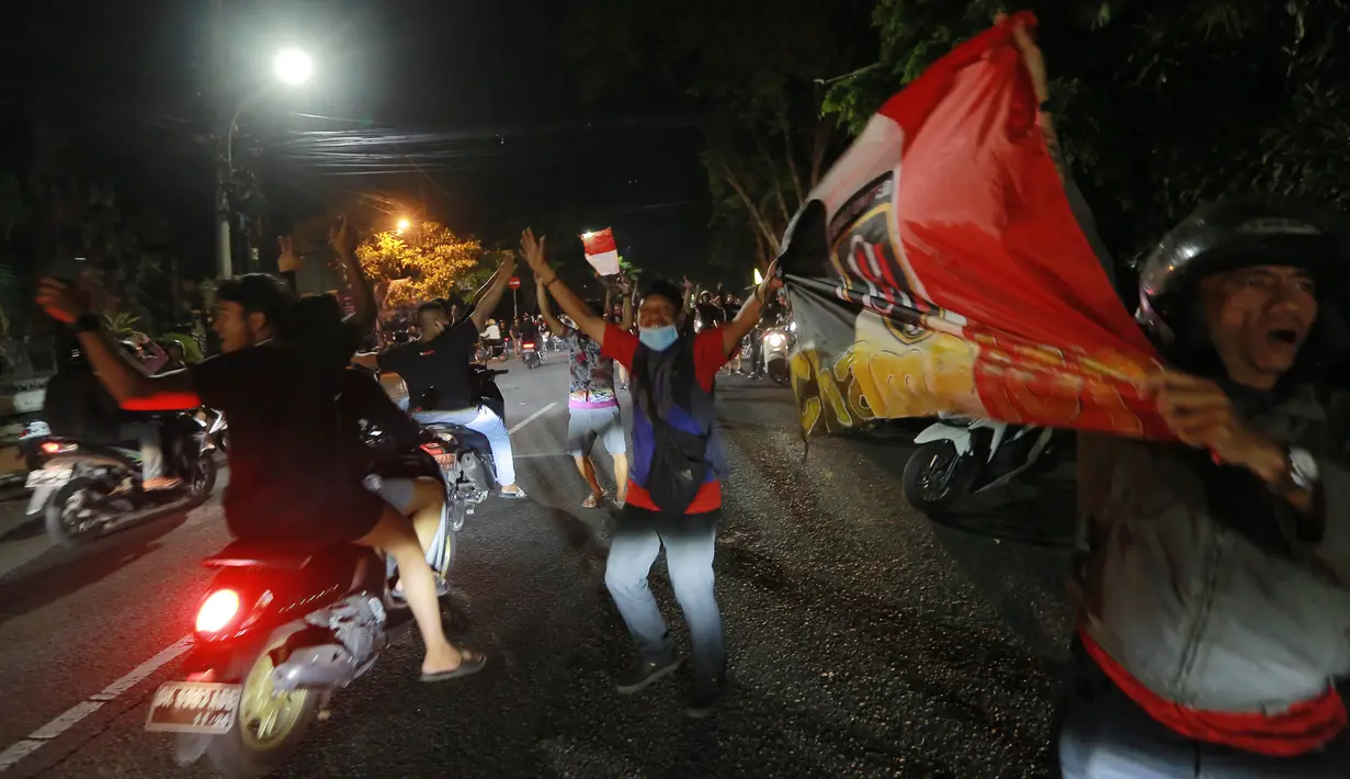 Sejumlah suporter Bali United turun ke jalan untuk merayakan keberhasilan tim kesayangannya menjuarai BRI Liga 1 2021/2022 di Bali, Sabtu (26/3/2022) dini hari. Skuat Serdadu Tridatu berhasil mencatatkan Back to Back usai berhasil mempertahankan juara pada 2019 lalu. (Bola.com/M Iqbal Ichsan)
