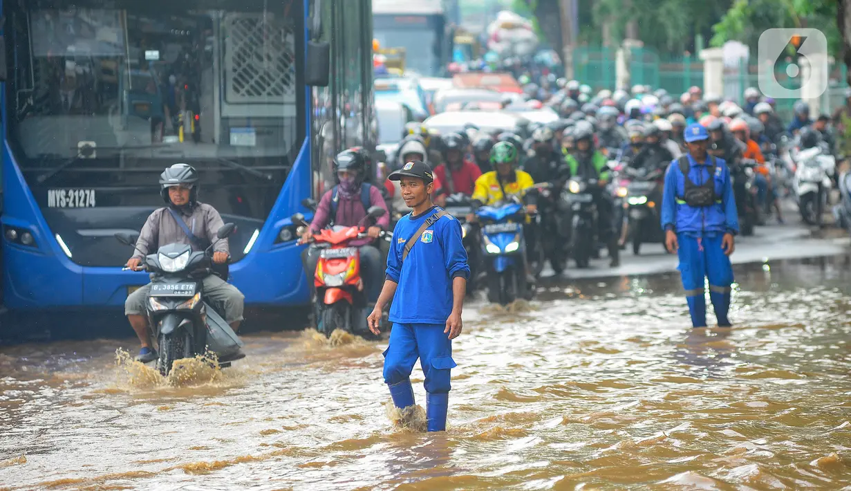 Pasukan Biru mengecek banjir yang meggenang di Jalan Raya Bogor depan Pasar Induk Kramat Jati, Jakarta, Kamis (30/11/2023). (merdeka.com/Arie Basuki)