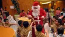 Seorang pria mengenakan kostum Sinterklas membagikan hadiah kepada bocah yang hadir dalam acara Christmas Tree Lighting Ceremony di Intercontinental Hotel, Jakarta. Foto diambil pada Kamis (27/11/2014). (Liputan6.com/Panji Diksana)