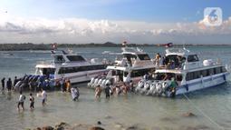 Wisatawan antre naik ke kapal boat menuju kawasan wisata Nusa penida dan Nusa lembongan di Pelabuhan Sanur, Denpasar, Bali, Senin (2/5/20222). Lebih dari seribu wisatawan tiap harinya melakukan perjalanan wisata pulang pergi. (merdeka.com/Arie Basuki)