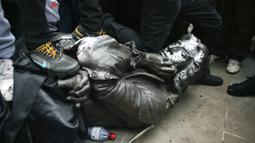 Demonstran merobohkan patung pedagang budak Edward Colston saat protes Black Lives Matter di Bristol, Inggris, Minggu (7/6/2020). Aksi tersebut dilakukan sebagai bentuk protes atas kematian George Floyd saat ditangkap oleh polisi di Amerika Serikat. (Ben Birchall/PA via AP)