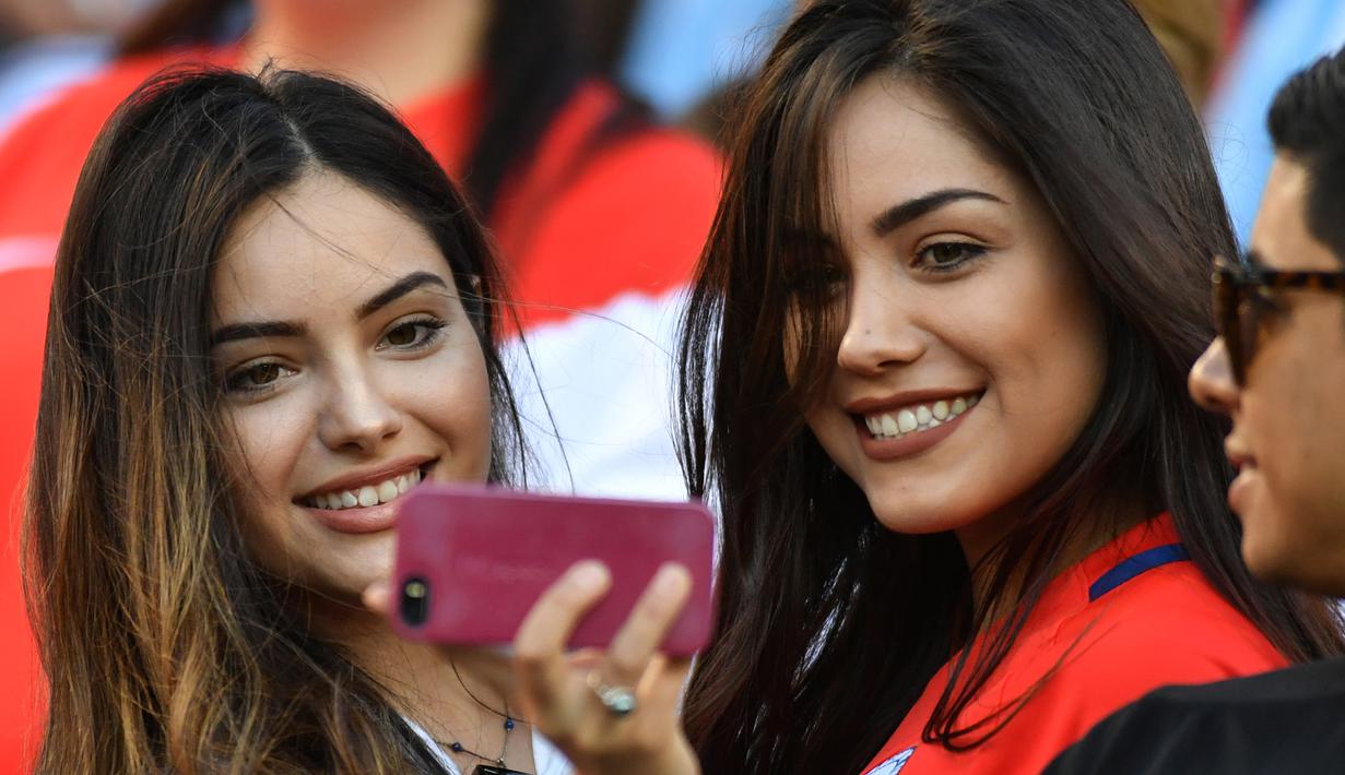 Dua suporter wanita Chile berselfie sebelum menyaksikan laga Argentina melawan Chile pada Copa America Centenario 2016 di Levi's Stadium, California, AS (7/6). Argentina menang atas Chile dengan skor 2-1. (AFP PHOTO/JOSH Edelson)