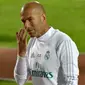 Pelatih Real Madrid, Zinedine Zidane, mengamati anak asuhnya saat latihan di Stadion NY University Abu Dhabi, UAE, Senin (11/12/2017). Los Blancos bersiap jelang semifinal FIFA Club World Cup. (AFP/Giuseppe Cacace)