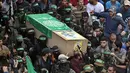Tentara Hamas mengenakan topeng dan membawa senjata mengiringi peti jenazah enam pejuang mereka yang tewas di Deir el-Balah, Jalur Gaza (6/5). Sebelumnya telah terjadi ledakan yang menewaskan enam pejuang Hamas pada Sabtu (5/5). (AP/Khalil Hamra)