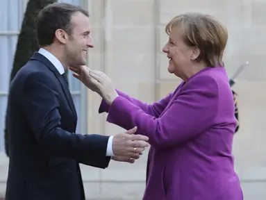Presiden Prancis Emmanuel Macron (kiri) menyambut Kanselir Jerman Angela Merkel saat tiba di Istana Presiden Eylsee di Paris (16/3). Pertemuan tersebut untuk membahas reformasi Uni Eropa. (AFP Photo/Ludovic Marin)