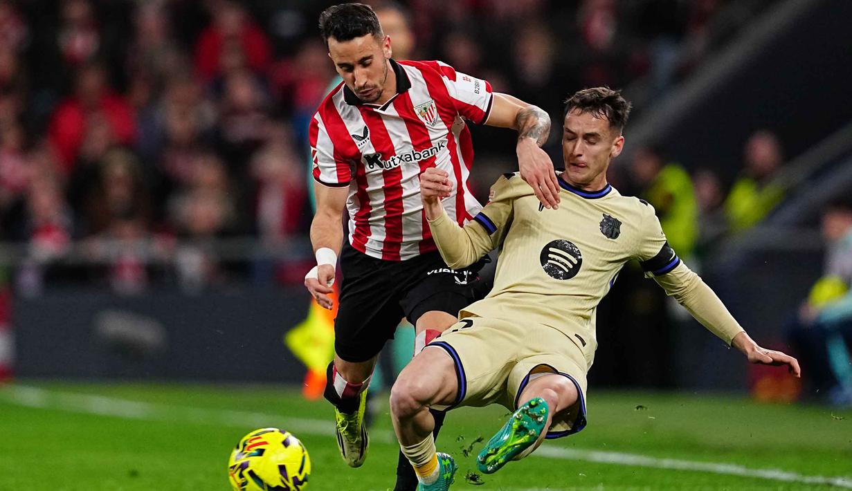 Tertinggal satu gol, Athletic Bilbao tampil semakin menekan. Mereka mencoba untuk menaikkan intensitas serangan dan tekanan mereka terhadap Barcelona. Tampak dalam foto, pemain Barcelona, Marc Casado (kanan) diadang oleh Alex Berenguer dari Athletic Bilbao pada pertandingan pekan ke-27 La Liga 2025/2026 di Stadion San Mames, Sabtu 7 Maret 2026 waktu setempat atau Minggu (8/3/2026) dini hari WIB. (AP Photo/Miguel Oses)