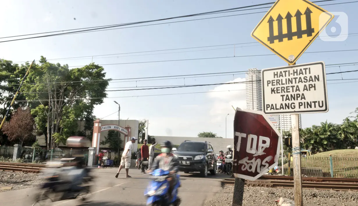 Kendaraan melintasi perlintasan kereta api di Jalan Duri Kosambi Raya, Jakarta, Rabu (15/1/2020).  Warga setempat membangun palang secara swadaya dan mengatur lalu lintas akibat perlintasan kereta dekat  Stasiun Rawa Buaya tersebut belum dipasang palang pintu otomatis. (merdeka.com/Iqbal Nugroho)