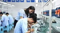Seorang guru mengajari siswa berlatih merakit perangkat elektronik di Sekolah Menengah Kejuruan Longhua Nanchuan di Kota Chongqing, China barat daya, pada 28 Juni 2019. (Xinhua/Wang Quanchao)