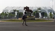 Pewarta melihat-lihat di salah satu pintu masuk kawasan Jakarta International Equestrian Park Pulomas, Jakarta, Kamis (2/8). JIEPP akan menjadi venue tiga cabang equestrian Asian Games 2018. (Liputan6.com/Helmi Fithriansyah)