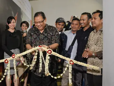 Menteri Koperasi dan UKM, AAGN Puspayoga memotong pita saat meresmikan pembukaan Anugerah Pewarta Foto Indonesia (APFI) 2017 di Jakarta, Jumat (21/4). Sebanyak 15 karya foto jurnalistik terbaik telah dipilih dari 5.488 karya. (Liputan6.com/Faizal Fanani)