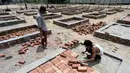 Para buruh bekerja membangun tempat kremasi di ladang kosong di New Delhi, India, Rabu (5/5/2021). India memperbanyak tempat kremasi karena meningkatnya jumlah kematian akibat virus corona COVID-19. (Money SHARMA/AFP)