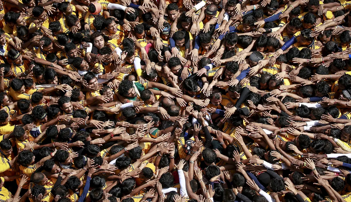 Ribuan umat Hindu membentuk piramida manusia untuk mencapai dan memecahkan dahi-handi (pot yang terbuat dari tanah liat) pada Festival Janmashtami di Mumbai, India, 6 September 2015. Festival ini menandai kelahiran dewa Krishna (REUTERS/Danish Siddiqui)