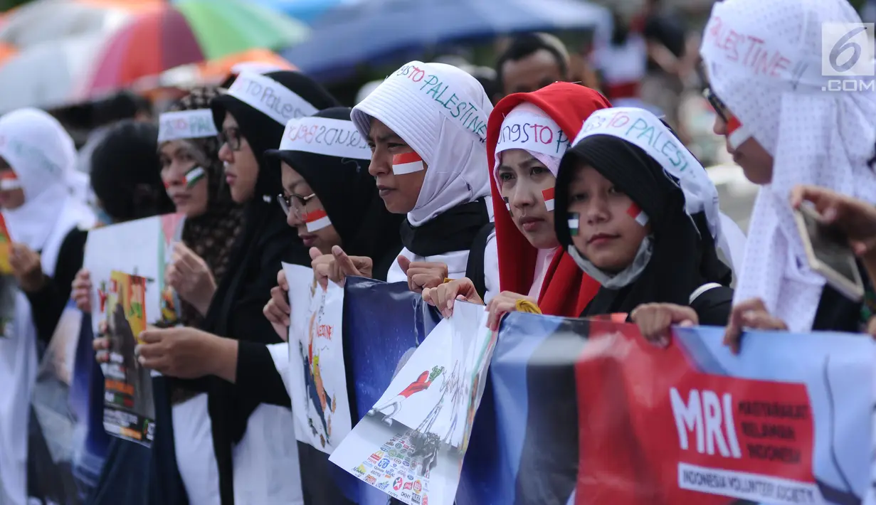Peserta aksi membentangkan spanduk saat aksi di kawasan Bundaran HI, Jakarta, Minggu (10/12). Mereka memprotes keputusan Presiden AS Donald Trump yang mengakui Yerusalem sebagai Ibu Kota Israel. (Liputan6.com/Helmi Fithriansyah)