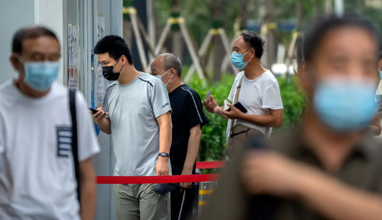 Orang-orang yang memakai masker berbaris untuk tes COVID-19 di fasilitas pengujian virus corona di Beijing, China, Jumat (12/8/2022). Penularan Omicron yang tinggi membuat lebih sulit untuk membersihkan infeksi. (AP Photo/Mark Schiefelbein)