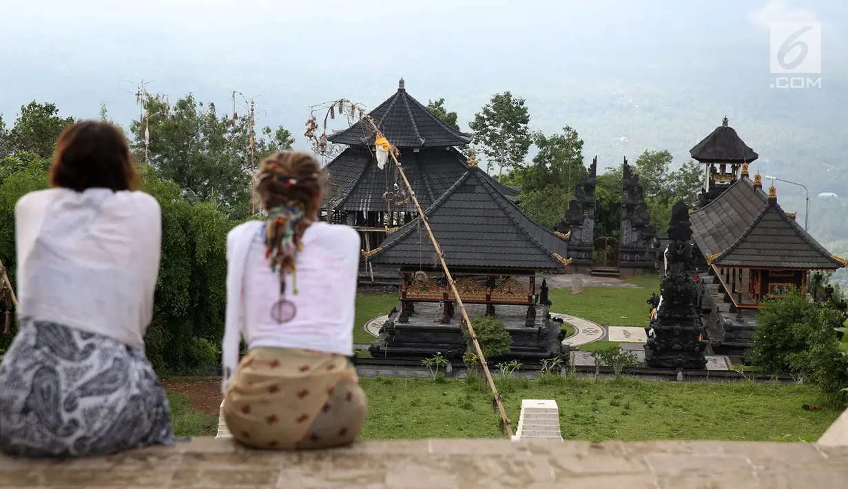 Wisatawan menikmati suasana di Pelataran Agung Pura Lempuyang, Karangasem, Bali, Kamis (7/12). Erupsi Gunung Agung menyebabkan sejumlah destinasi wisata di kawasan Bali Timur mengalami penurunan jumlah wisatawan. (Liputan6.com/Immanuel Antonius)