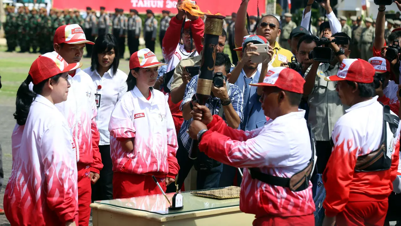  MenterKoordinator Bidang Pembangunan Manusia dan Kebudayaan (Menko PMK) Puan Maharani, mengambil dan melepas api PON