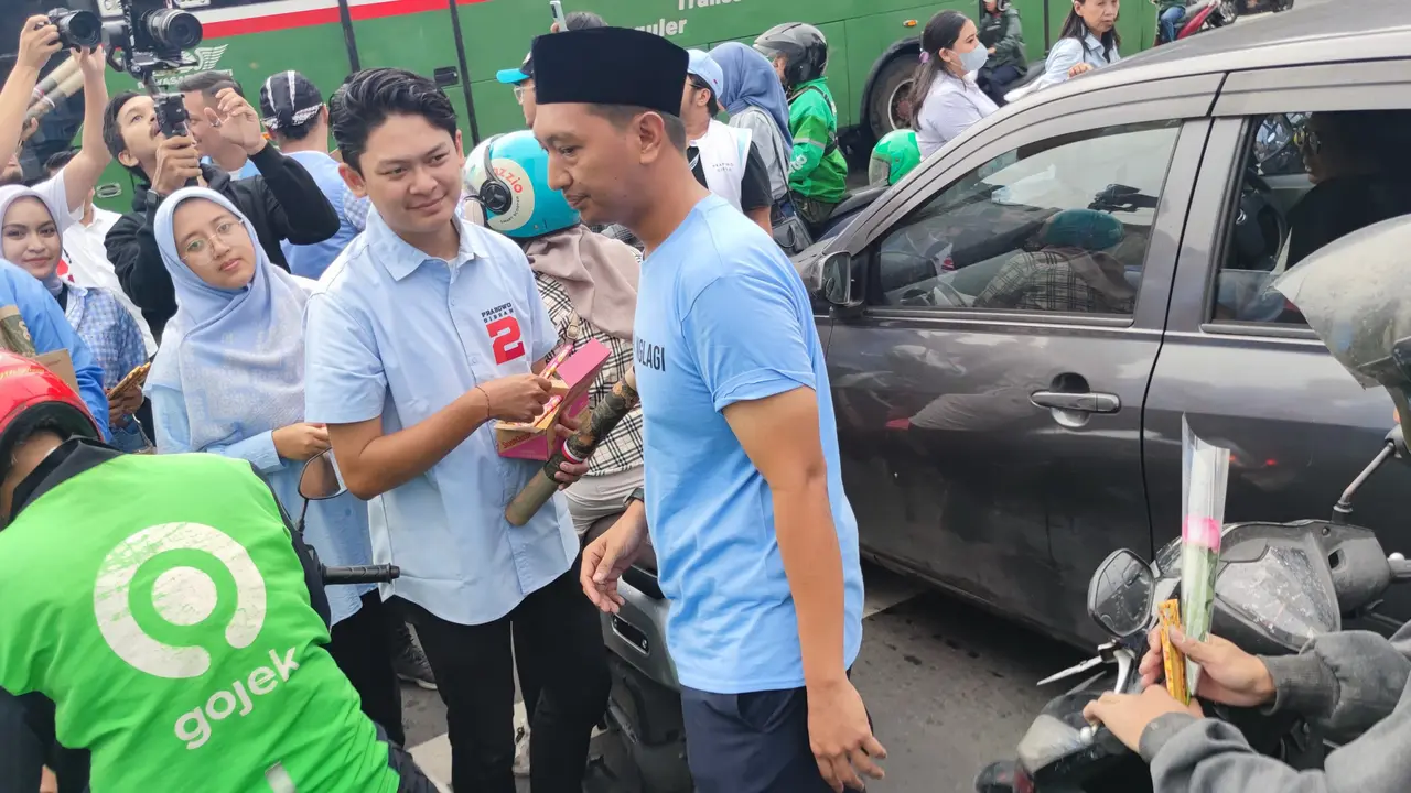 Tim Kampanye Nasional Pemilih Muda (TKN Fanta) Prabowo Subianto-Gibran Rakabuming Raka melakukan aksi bagi-bagi bunga dan cokelat kepada masyarakat di kawasan Thamrin, Jakarta Pusat, Kamis (15/2/2024). (Liputan6.com/Ady Anugrahadi)