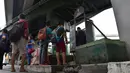 Warga mengantre menggunakan toilet umum di sepanjang jalan utama di Manila, Filipina, (24/11). Tidak seperti umumnya, toilet di Filipina ini dibangun di bawah jembatan dan berada di tempat terbuka. (AFP Photo/Ted Aljibe)