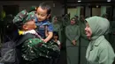 Personel TNI AD yang tergabung dalam kontingen AASAM menggendong sang buah hati saat penyambutan kedatangan di Bandara Soetta, Banten, Senin (23/5/2016). TNI AD menjadi juara umum AASAM 2016 yang digelar di Australia. (Liputan6.com/Helmi Fithriansyah)