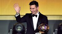 Pemain Barcelona, Lionel Messi melambaikan tangan sambil memegang trofi setelah memenangkan pemain terbaik dunia FIFA Ballon d'Or 2015 di Kongresshaus, Zurich, Senin ( 11/1). Ini adalah kelima kalinya Messi meraih Ballon d'Or. (AFP PHOTO/FABRICE COFFRINI)