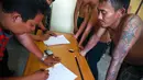 Petugas kepolisian terlihat melakukan pendataan identitas 112 preman tersebut, Jakarta, Jumat (29/8/14). (Liputan6.com/Faizal Fanani)