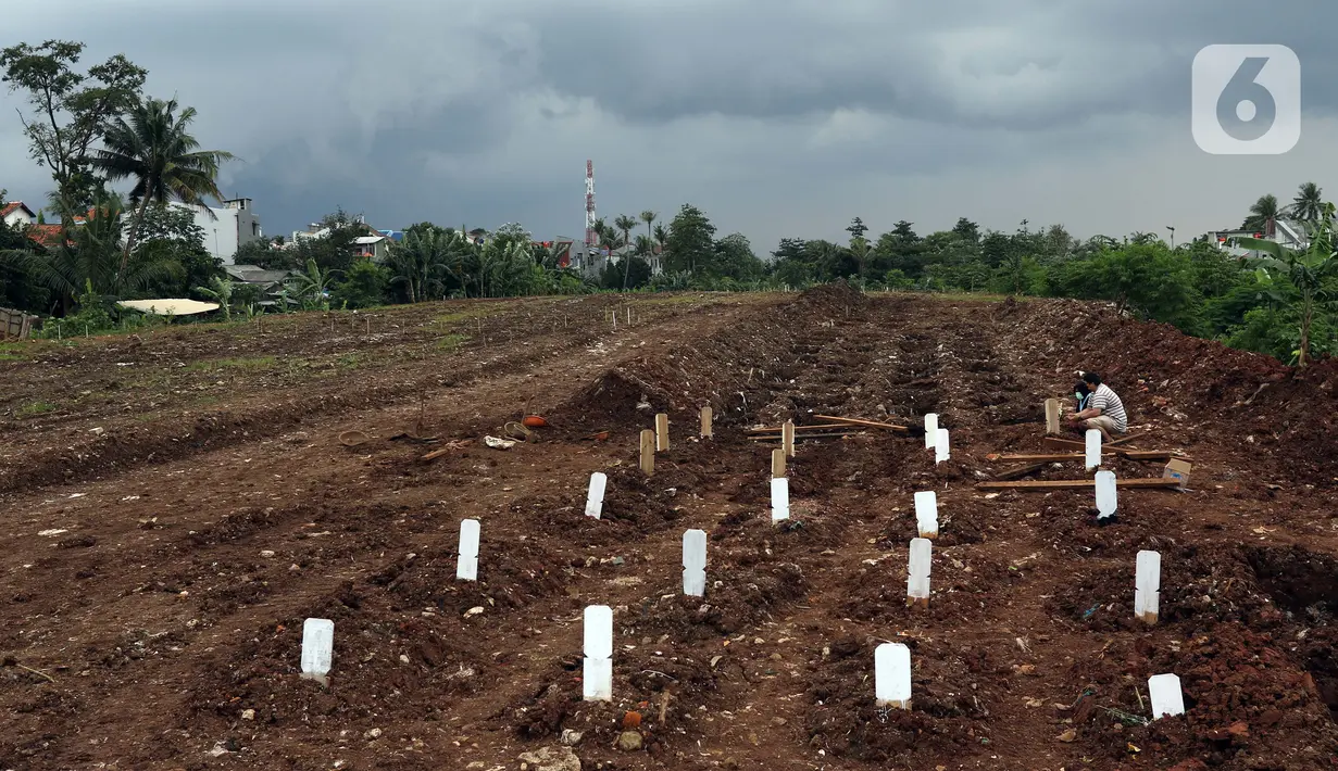 Pihak keluarga melakukan ziarah makam di area khusus pemakaman jenazah dengan protokol COVID-19 di TPU Srengseng Sawah Dua, Jakarta, Selasa, (2/2/2021). TPU Srengseng Sawah 2, saat ini mulai menerima pemakaman jenazah protokol COVID-19 dengan kapasitas 1.020 petak. (Liputan6.com/Helmi Fithriansyah)