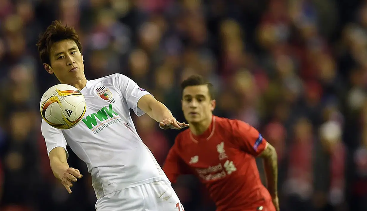 Pemain Augsburg, Koo Ja-Cheol, menahan laju bola dibayangi gelandang Liverpool, Philippe Coutinho. The Reds juga lebih sering melakukan tendangan ke arah gawang yaitu sebanyak enam kali. (EPA/Peter Powell)