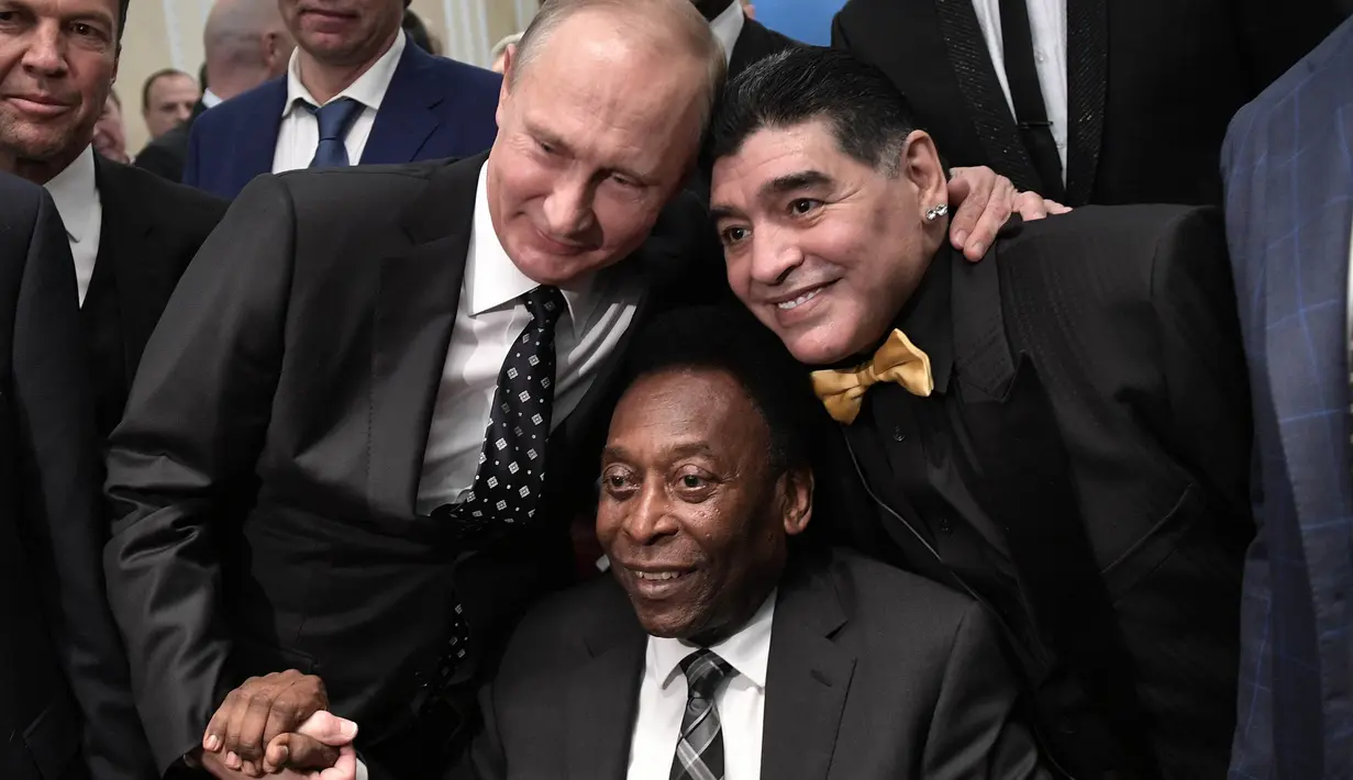 Legenda sepak bola, Diego Maradona dan Pele, foto bersama dengan Presiden Rusia, Vladimir Putin, saat menghadiri Drawing Piala Dunia 2018 di Kremlin Palace, Jumat (1/12/2017). Acara tersebut dihadiri legenda sepak bola dunia. (AFP/Alexey Nikolsky)