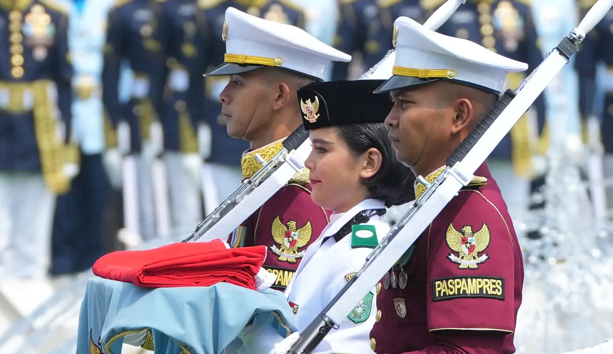 Seorang pembawa bendera, yang dikawal oleh pasukan kehormatan, berbaris dalam upacara pengibaran bendera untuk memperingati hari ulang tahun kemerdekaan negara yang ke-81 di Istana Merdeka, Jakarta, Indonesia, Senin, 17 Agustus 2026. (Foto AP/Tatan Syuflana)