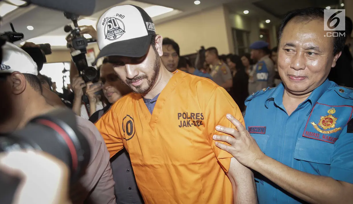 Petugas mengawal aktor Fachri Albar saat rilis kasus narkoba di Polres Jakarta Selatan, Rabu (14/2). Penangkapan Fachri tersebut menambah panjang daftar artis yang ditangkap karena narkoba. (Liputan6.com/Faizal Fanani)