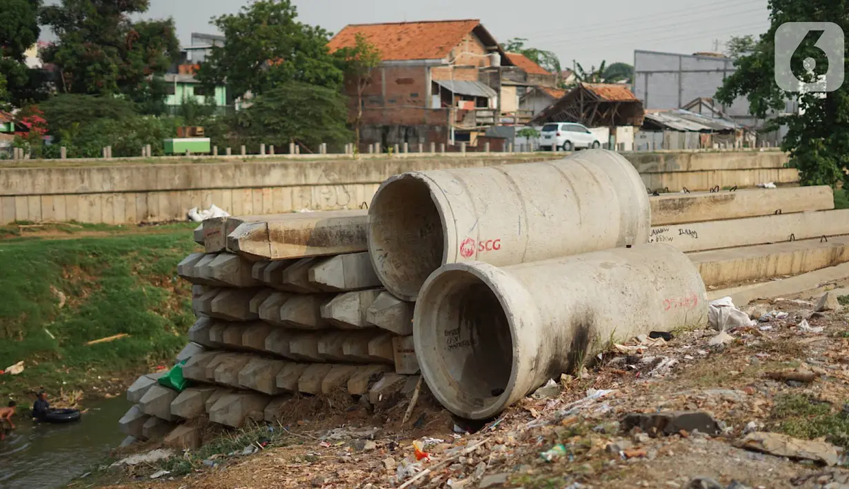 Tiang pancang dan saluran gorong-gorong menghiasi bantaran Sungai Ciliwung di kawasan Rawajati, Jakarta, Rabu (30/10/2019). Tiang-tiang pancang itu merupakan sisa proyek normalisasi Sungai Ciliwung dan telah berada di bantaran tersebut selama beberapa tahun terakhir. (Liputan6.com/Immanuel Antonius)