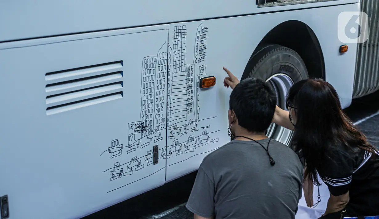 Penyandang disabilitas menggambar di salah satu bus Transjakarta di Kantor Pusat PT Transportasi Jakarta, Kamis (1/12/2022). Menyambut hari Disabilitas pada tanggal 3 Desember, sejumlah anak-anak berkebutuhan khusus melukis bus Transjakarta Mereka bebas melukis apa saja di badan bus yang telah disiapkan. (Liputan6.com/Faizal Fanani)