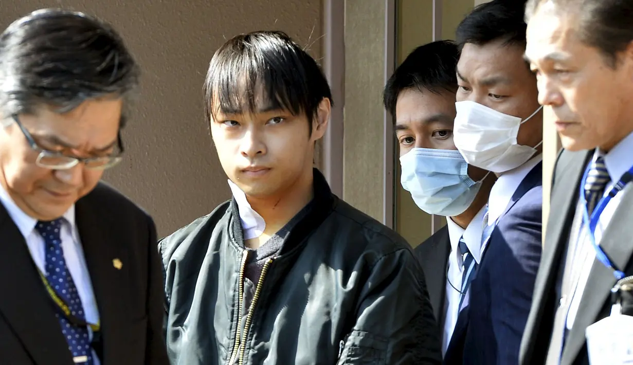 Kabu Terauchi (kedua kiri) dikawal petugas meninggalkan rumah sakit menuju kantor polisi di Izunokuni, Jepang, Kamis (31/3). Pria 23 tahun itu ditangkap lantaran menyekap gadis remaja selama dua tahun di dalam apartemen miliknya. (REUTERS/Kyodo)