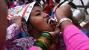 Seorang anak Nepal meminum susu saat mengikuti Gai Jatra cow festival di Kathmandu, Nepal (8/8). (AFP Photo/Prakash Mathema)