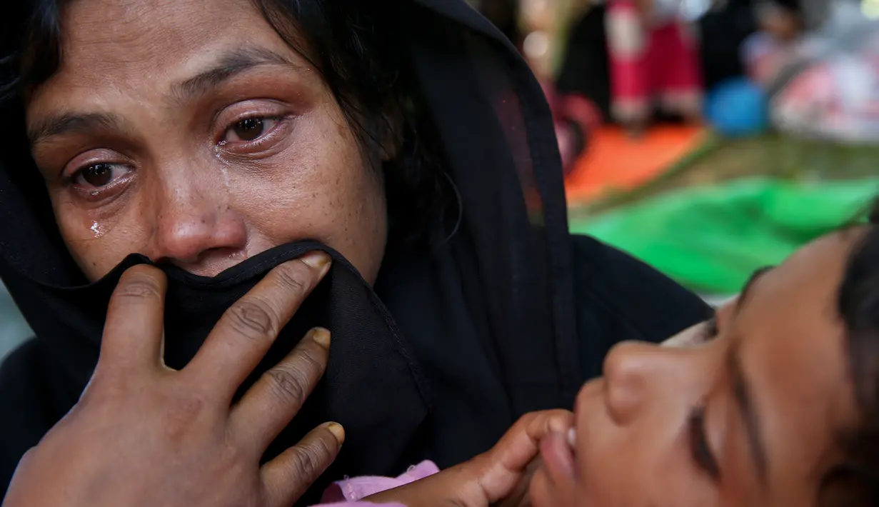 Seorang wanita Rohingya bersama anaknya menangis setelah dihadang petugas perbatasan di sebuah tempat penampungan darurat di Ghumdhum, Cox's Bazar, Bangladesh, (27/8). (AP Photo/Mushfiqul Alam)