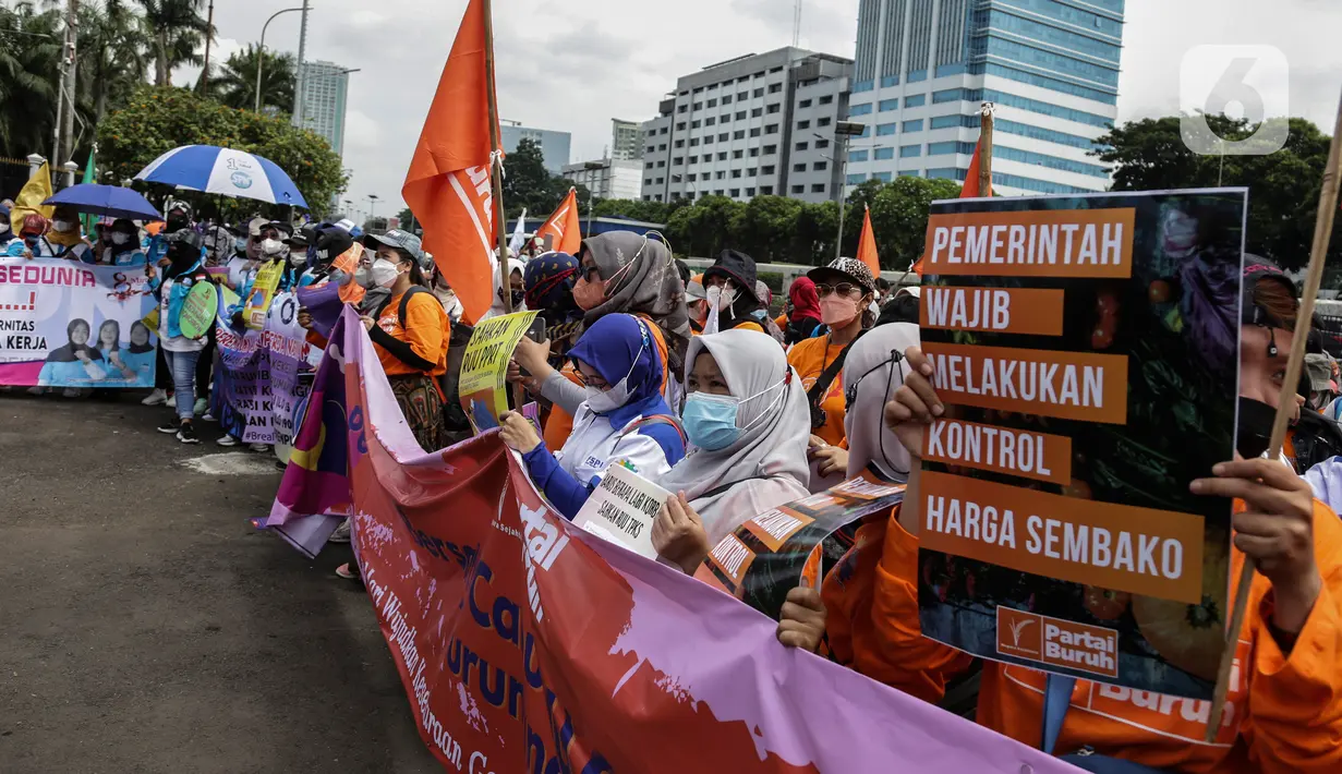 Sejumlah buruh perempuan memegang poster saat menggelar aksi di depan gedung DPR RI, Jakarta, Selasa (8/3/2022). Buruh perempuan yang tergabung dari beberapa serikat buruh menggelar aksi memperingati Hari Perempuan Internasional atau International Women's Day (IWD) 2022. (Liputan6.com/Johan Tallo)