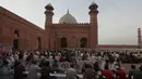 Orang-orang berbuka puasa selama bulan suci Ramadhan di masjid bersejarah Badshahi, di Lahore, Pakistan (3/4/2022). Ramadhan ditandai dengan puasa setiap hari dari fajar hingga matahari terbenam. (AP Photo/K.M. Chaudary)