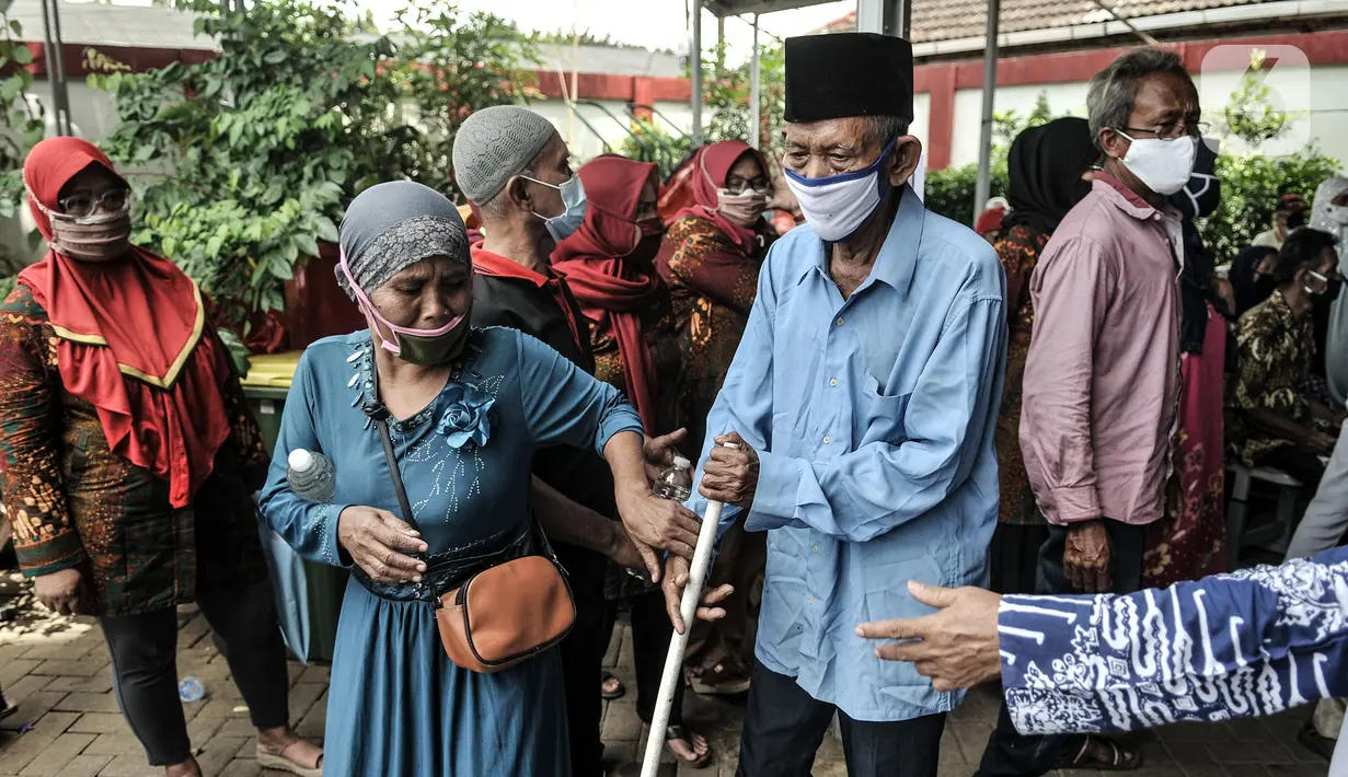Warga lanjut usia (lansia) didampingi keluarga saat mengikuti vaksinasi COVID-19 di SDN 02 Sukapura, Cilincing, Jakarta Utara, Senin (22/3/2021). Pemkot Jakarta Utara menggelar vaksinasi COVID-19 secara bergilir di tiap kelurahan. (merdeka.com/Iqbal S. Nugroho)