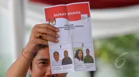 Seorang pegawai KPU memperlihatkan surat suara yang tidak sah saat simulasi di Halaman Gedung KPU RI, Jakarta Pusat, Selasa (7/4/2015). Surat suara dinyatatakan tidak sah karena dicontreng.   (Liputan6.com/Herman Zakharia)
