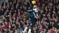 Penyerang Fulham, Raul Jimenez melakukan duel di udara melawan bek Arsenal, Gabriel Magalhaes dalam laga lanjutan Premier League 2023/2024, Minggu (31/12/2023) malam WIB. (AFP/Adrian Dennis)